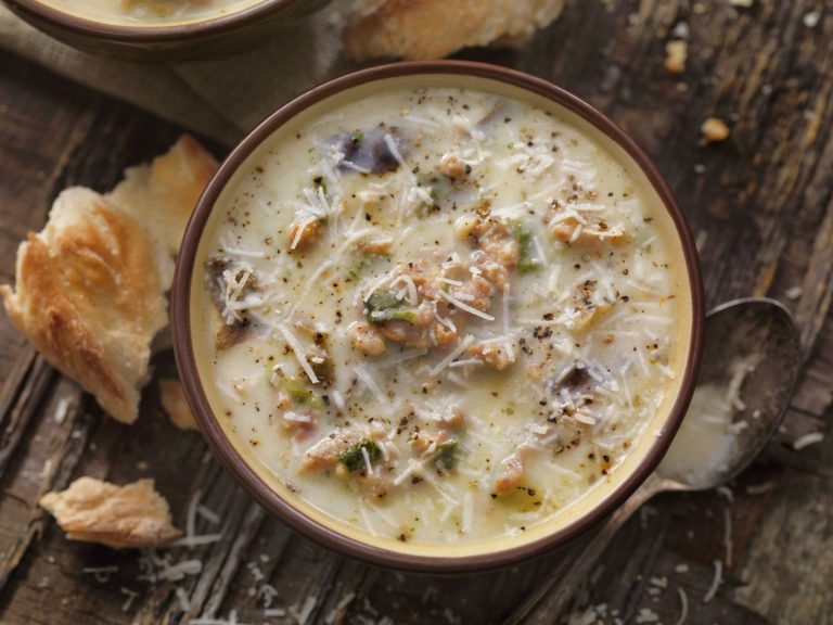 Hearty potato and kale soup with sausage and parmesan cheese according to Italian recipe