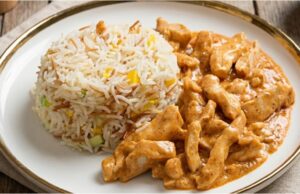 Delicious Chicken Strips with Garlic and Vegetable Rice Chicken strips in a delicate garlic sauce with colorful rice – a quick and affordable meal for the whole family