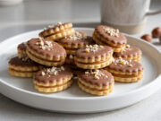 Almond Ovals: Delicate Christmas Cookies Filled with Lotus Spread and Topped with Chocolate Almond ovals with chocolate and chopped almonds