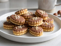 Almond Ovals: Delicate Christmas Cookies Filled with Lotus Spread and Topped with Chocolate Almond ovals with chocolate and chopped almonds