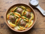 Baked Potatoes with Meatballs: Hearty Family Meal with Béchamel and Cheese Baked potatoes with meatballs, carrots, béchamel and cheese in a baking dish