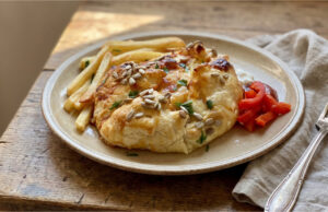 Camembert in Puff Pastry: Crispy Starter with Bacon Ready in 30 Minutes Camembert in puff pastry with bacon and onion on a plate
