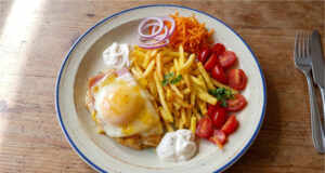 Chicken Breast with Ham, Cheese and Peach: A Retro Lunch with Fries Chicken breast with ham, cheese and peach served with fries