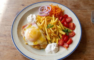 Chicken Breast with Ham, Cheese and Peach: A Retro Lunch with Fries Chicken breast with ham, cheese and peach served with fries