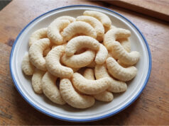 Coconut Crescents: Simple Christmas Cookies with a Delicate Flavor and Golden Finish Coconut crescents on a baking tray with a golden finish