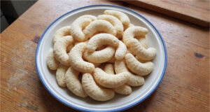 Coconut Crescents: Simple Christmas Cookies with a Delicate Flavor and Golden Finish Coconut crescents on a baking tray with a golden finish
