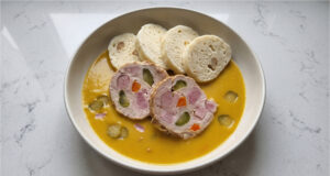 Hamburg Pork with Bread Dumplings: Traditional Sunday Lunch with Creamy Vegetable Sauce Hamburg pork with bread dumplings and creamy vegetable sauce served on a plate