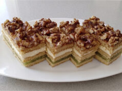 Honey Cake Slices with Apples: Three Honey Layers, Delicate Cream, and Refreshing Fruit Filling Honey cake slices with apples on a tray topped with chocolate glaze