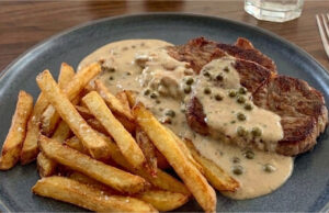 Juicy Pork Neck Steak with Green Pepper Sauce and Fries Juicy pork neck steak with green pepper sauce and homemade fries
