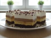Sinfully Delicious Kinder Bueno Slices with Walnuts, Nutella, Pudding Cream, and BeBe Biscuits Kinder Bueno slices with fluffy walnut base, two pudding creams, and whipped cream.