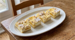 Linzer Grated Slices with Quark and Fruit: Tender Pastry and Fluffy Filling Linzer slices with quark and fruit on a tray