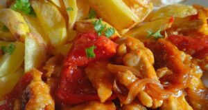 Tender Pork Strips in Curry Vegetable Sauce with Fragrant Roasted Potatoes Pork loin with vegetables and curry in a pan – juicy meat thanks to starch coating