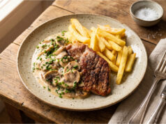 Pork Neck with Mushroom Sauce and Fries: Juicy Lunch Quickly Made in a Pan Pork neck with mushroom sauce and fries served on a plate