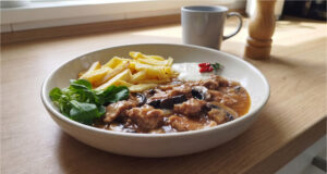 Pork Neck with Mushrooms: Juicy Meat in a Rich Sauce with Crispy Fries Juicy pork neck with mushrooms and crispy fries