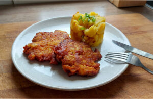 Pork Neck Meat Patties: Rested Overnight and Fried to Golden Perfection Golden pork neck meat patties with mashed potatoes and fried onions