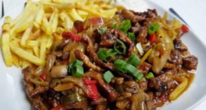 Pork Strips in One Pan: Juicy Meat with Vegetables, Mushrooms, and Crispy Fries Recipe for Chinese-style pork stir-fry with vegetables and fries