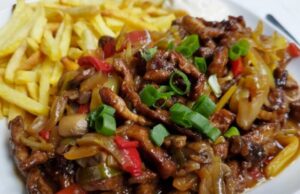 Pork Strips in One Pan: Juicy Meat with Vegetables, Mushrooms, and Crispy Fries Recipe for Chinese-style pork stir-fry with vegetables and fries