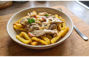 Krakonoš’s Fire from Chicken: Spicy Creamy Mix with Crispy Fries Spicy creamy chicken mix with crispy fries on a plate