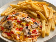 Chicken Cutlets Pizza Style: Juicy Meat with Cheese and Vegetables on One Tray Chicken cutlets pizza style with juicy meat, cheese, and vegetables on a tray