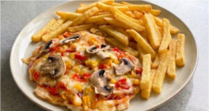 Chicken Cutlets Pizza Style: Juicy Meat with Cheese and Vegetables on One Tray Chicken cutlets pizza style with juicy meat, cheese, and vegetables on a tray