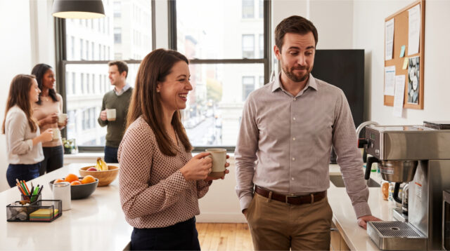 coworkers-chatting-office-kitchen Coworkers chatting in the office kitchen.