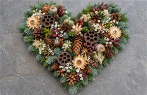 Fir, Cone and Flower Hearts: 20 Beautiful All Souls’ Day Decorations You Can Make at Home Richly decorated natural heart with fir, cones, and flowers