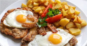 Holstein Pork Chop: Juicy Meat with Fried Egg, Bacon, and Crispy Potatoes Holstein pork chop recipe with fried egg and bacon