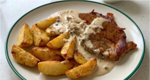 Pork Neck Steak with Pepper Sauce: Juicy Meat and Golden Roasted Potatoes Pork neck steak with pepper sauce, juicy meat and golden roasted potatoes