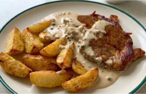Pork Neck Steak with Pepper Sauce: Juicy Meat and Golden Roasted Potatoes Pork neck steak with pepper sauce, juicy meat and golden roasted potatoes
