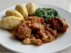 Pork Roast with Potato Dumplings and Spinach: Slow-Roasted Lunch with Beer Gravy Golden roasted pork belly with potato dumplings and creamy spinach on a plate