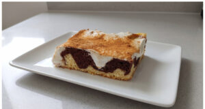 Two-Tone Cake with Pudding and Sour Cream: Moist Dessert with a Hint of Cinnamon Two-tone cake with pudding and sour cream on a tray