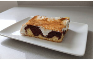 Two-Tone Cake with Pudding and Sour Cream: Moist Dessert with a Hint of Cinnamon Two-tone cake with pudding and sour cream on a tray